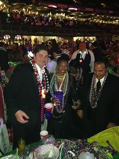 Guests wearing beads at an indoor Mardi Gras event