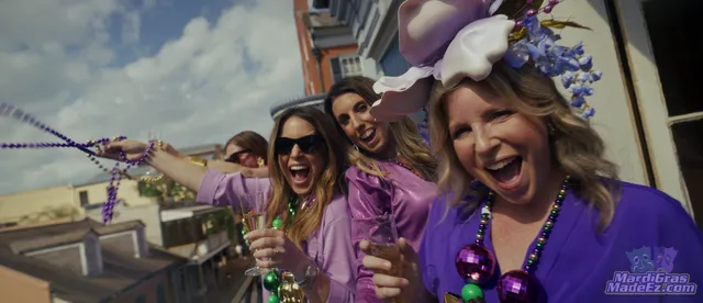 Guests in purple and green celebrating on a balcony